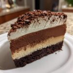 Decadent Triple Chocolate Mousse Cake with Cocoa Dusted Topping.