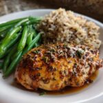 Baked chicken breast with lemon-garlic, served alongside steamed green beans and wild rice.